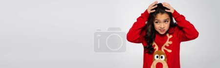 Scared kid in red sweater looking away isolated on grey, banner 