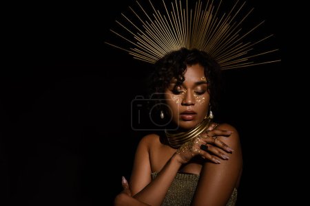 confident african american woman with golden crown and paint on cheeks posing isolated on black