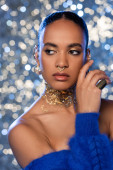 Portrait of trendy african american model with golden accessories looking away on sparkling background  Sweatshirt #620708966
