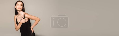 Photo for Young model with vitiligo posing in black dress on grey background, banner - Royalty Free Image