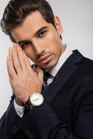 Porträt eines gut aussehenden und jungen Geschäftsmannes in formeller Kleidung isoliert auf grau