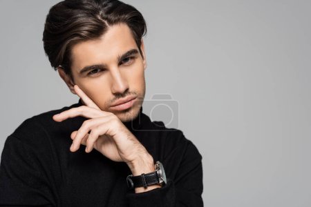 portrait of brunette model in black turtleneck posing isolated on grey with copy space