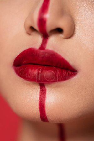 close up view of cropped woman with red lips and vertical line on face 