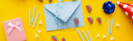 Photo for Top view of sweets near envelope and festive candles on yellow background, banner - Royalty Free Image