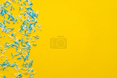 Téléchargez les photos : Vue de dessus des arrosages doux bleus et blancs sur fond jaune - en image libre de droit