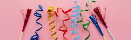 Top view of colorful serpentine and drinking straws with tinsel on pink background, banner 