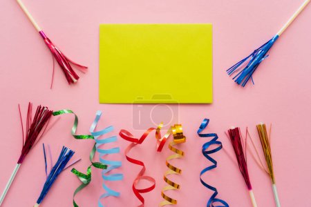 Top view of empty greeting card near serpentine and drinking straws with tinsel on pink background 