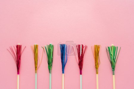 Photo for Top view of drinking straws with colorful tinsel on pink background with copy space - Royalty Free Image