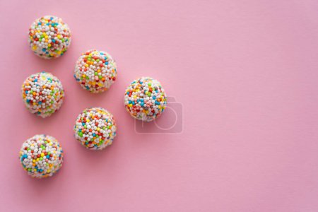 Płaskie leżanki smaczne cukierki z miejsca na ksero na różowym tle 