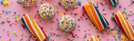 Top view of delicious sweets and sprinkles on pink background, banner 