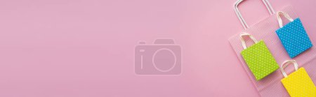 Téléchargez les photos : Vue du dessus des sacs à provisions sur fond rose avec espace de copie, bannière - en image libre de droit