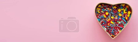 Téléchargez les photos : Vue du dessus des paillettes colorées en forme de coeur boîte cadeau sur fond rose, bannière - en image libre de droit
