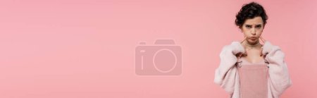 Téléchargez les photos : Offensé femme regardant caméra et toucher les joues gonflées isolé sur rose, bannière - en image libre de droit