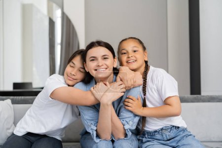 Glücklich asiatisch kids hugging mutter auf couch bei zuhause 