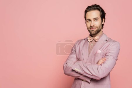 Photo for Confident host of event crossing arms and looking at camera on pink background - Royalty Free Image