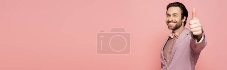 Photo for Positive host of event showing thumb up at camera isolated on pink, banner - Royalty Free Image
