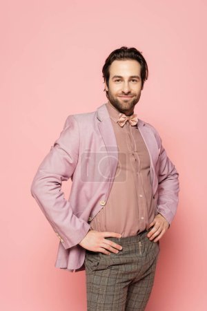 Photo for Trendy host of event posing and looking at camera on pink background - Royalty Free Image
