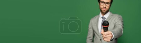 Téléchargez les photos : Newscaster flou en costume tenant microphone isolé sur vert avec espace de copie, bannière - en image libre de droit