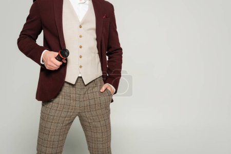 Photo for Cropped view of showman in formal wear standing with hand in pocket and holding microphone isolated on grey - Royalty Free Image