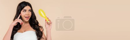 Dreamy woman with healthy hair holding hairbrush isolated on beige, banner 