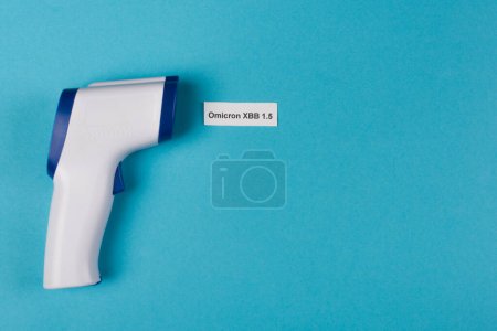 Photo for Top view of pyrometer near omicron xbb lettering on blue background - Royalty Free Image