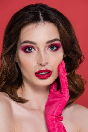 portrait of pretty woman with magenta color eye shadow isolated on pink 