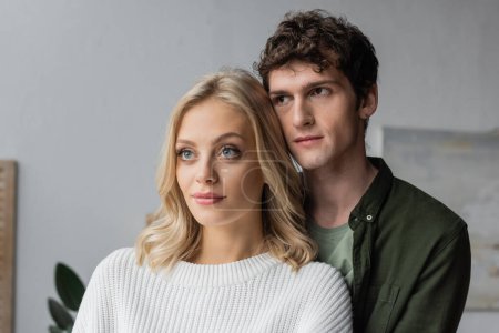 portrait of curly young man and blonde woman in white sweater 