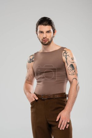Photo for Stylish tattooed man in tank top posing isolated on grey - Royalty Free Image