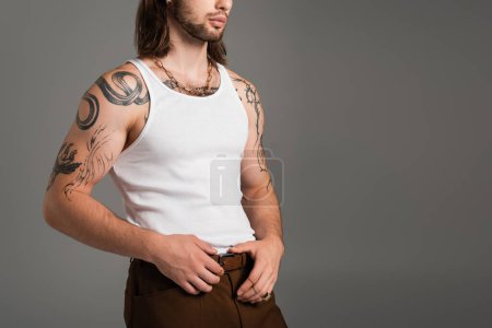 Photo for Cropped view of stylish tattooed man posing in tank top isolated on grey - Royalty Free Image