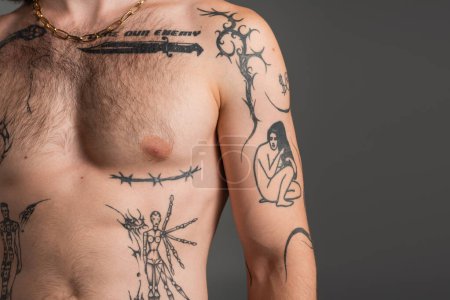 Cropped view of shirtless and tattooed man standing isolated on grey 