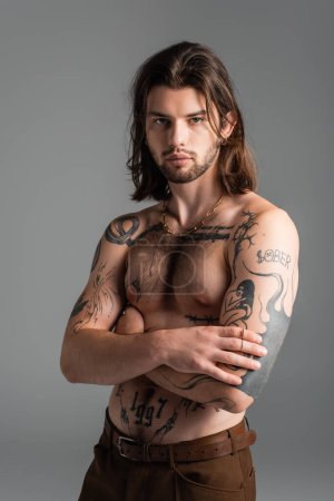 Photo for Muscular tattooed model posing while standing isolated on grey - Royalty Free Image