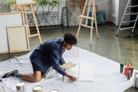 Artiste afro-américain avec peinture de palette sur toile en atelier 