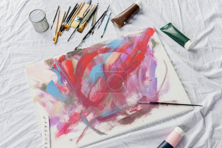 Téléchargez les photos : Top view of drawing near paintbrushes on cloth on floor in studio - en image libre de droit