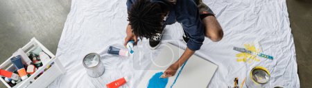 Foto de Vista aérea de la pintura de artista afroamericano sobre lienzo en el suelo en el taller, pancarta - Imagen libre de derechos
