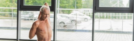 Photo for Shirtless man stretching back near windows in yoga studio, banner - Royalty Free Image
