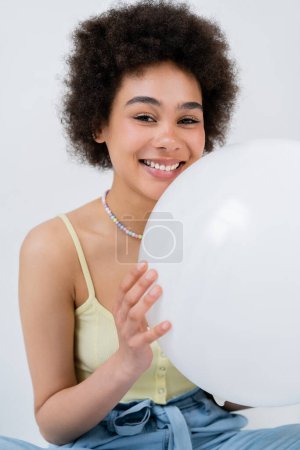 Photo for Portrait of positive african american woman holding balloon isolated on grey - Royalty Free Image