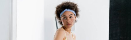 Photo for Portrait of african american woman in headband standing on grey background, banner - Royalty Free Image