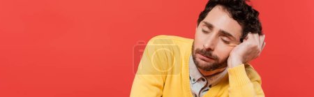 tired man in yellow long sleeve jumper sleeping isolated on coral background, banner 