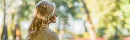 Photo for Side view of middle aged woman looking away in blurred park, banner - Royalty Free Image