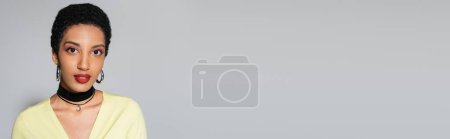 Photo for Stylish african american woman with makeup looking at camera on grey background, banner - Royalty Free Image