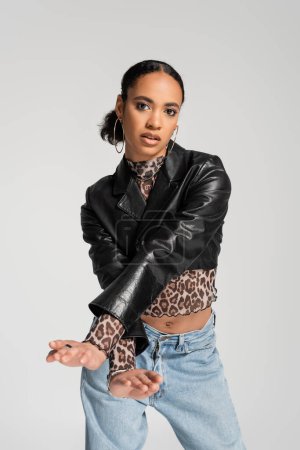 glamorous african american woman in black cropped jacket posing isolated on grey 