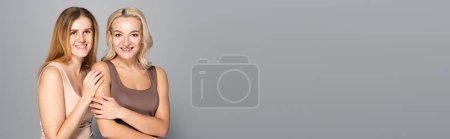 Smiling women with freckles and acne on skin standing on grey background, banner 