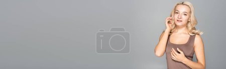 Photo for Pretty blonde woman with skin issue looking at camera isolated on grey, banner - Royalty Free Image