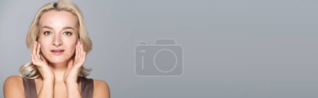 Photo for Pretty woman with acne on skin touching face isolated on grey, banner - Royalty Free Image