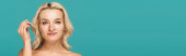 blonde woman with skin imperfections on face holding pipette with treatment serum isolated on turquoise, banner  Poster #648034396