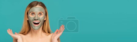 Téléchargez les photos : Femme excitée aux cheveux roux et masque d'argile sur le visage geste isolé sur turquoise, bannière - en image libre de droit