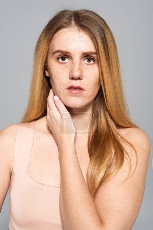 Photo for Portrait of freckled young woman with red hair looking at camera isolated on grey - Royalty Free Image