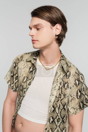 stylish pangender person in necklace and animal print blouse isolated on grey