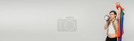 Téléchargez les photos : Jeune non binaire avec drapeau lgbt criant en mégaphone isolé sur gris, bannière - en image libre de droit