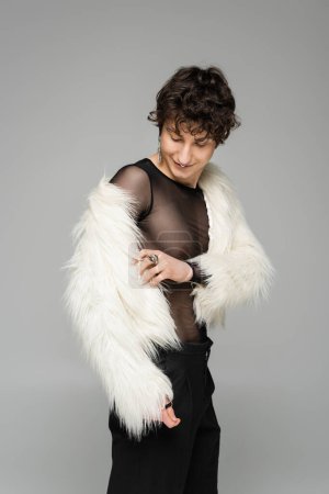 Photo for Brunette nonbinary person wearing white faux fur jacket isolated on grey - Royalty Free Image